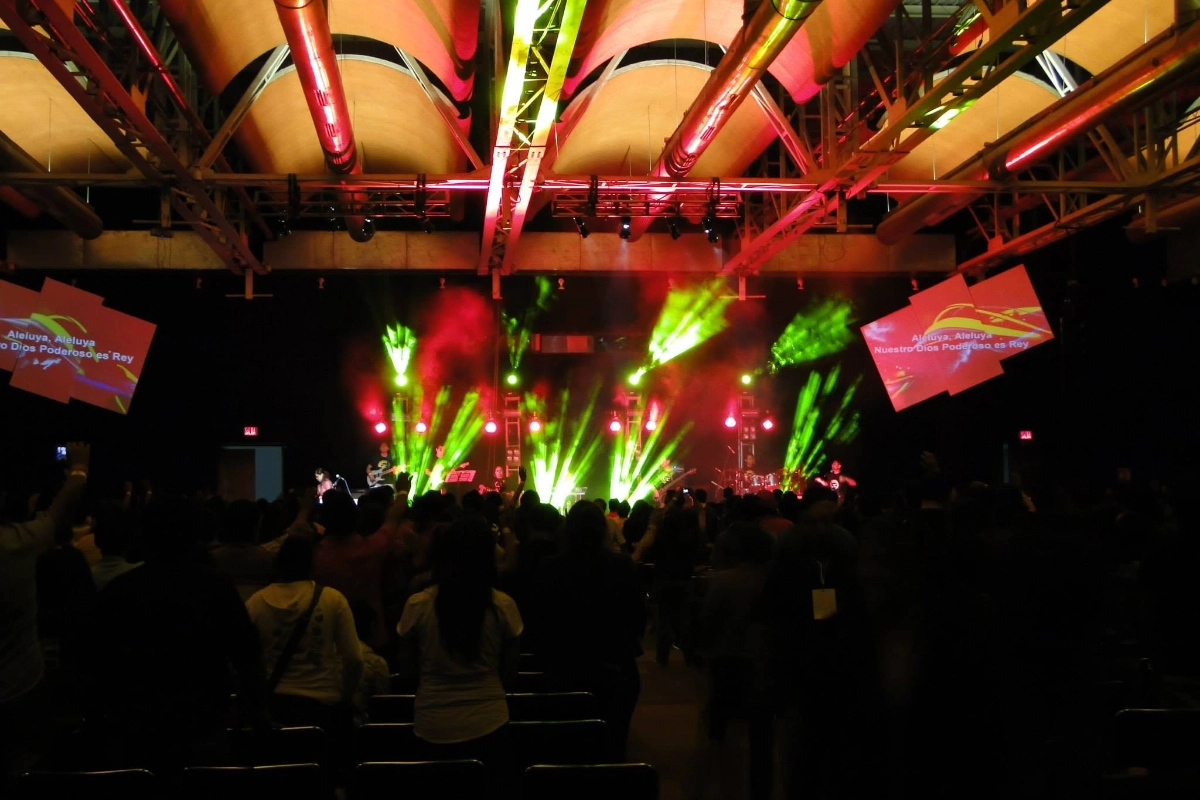 Large live event with the system running: two separated, symmetrical screens — videomapping plus the pipeline, lyrics over moving visuals rather than a mirrored projection.